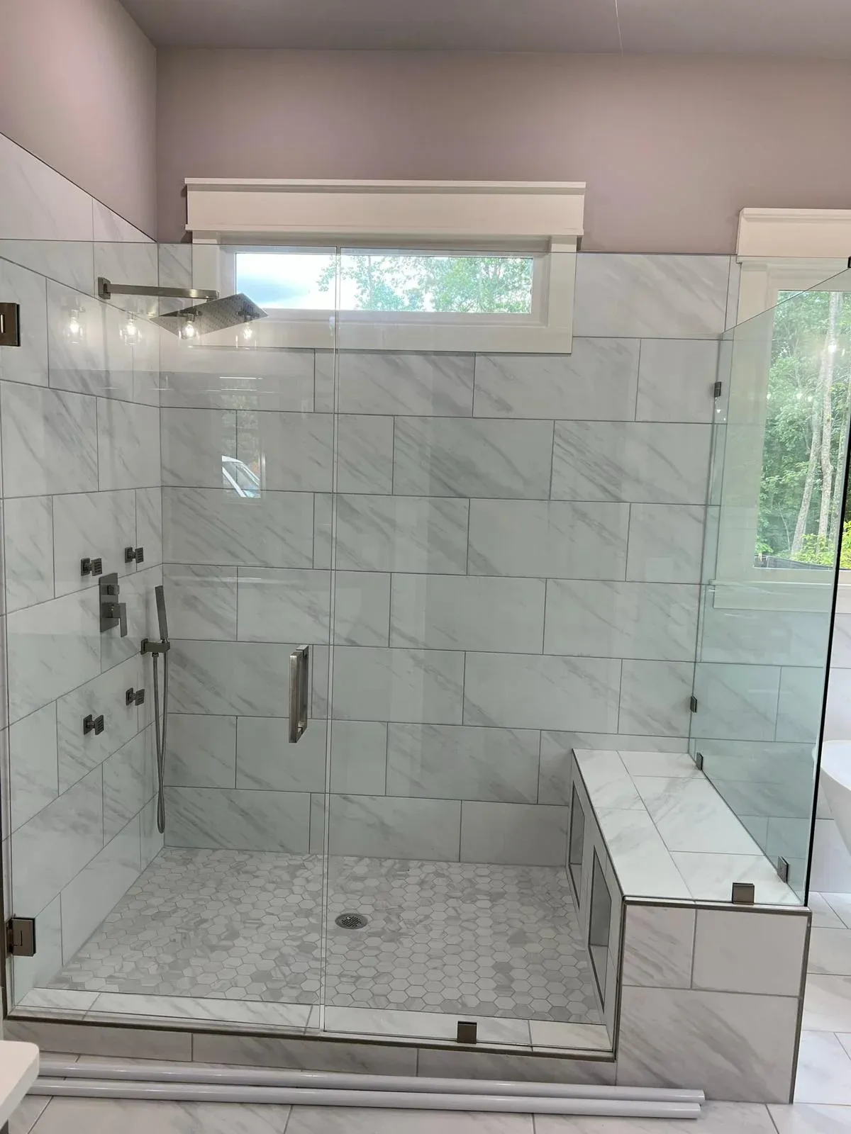 Finished marble shower with frameless glass enclosure
