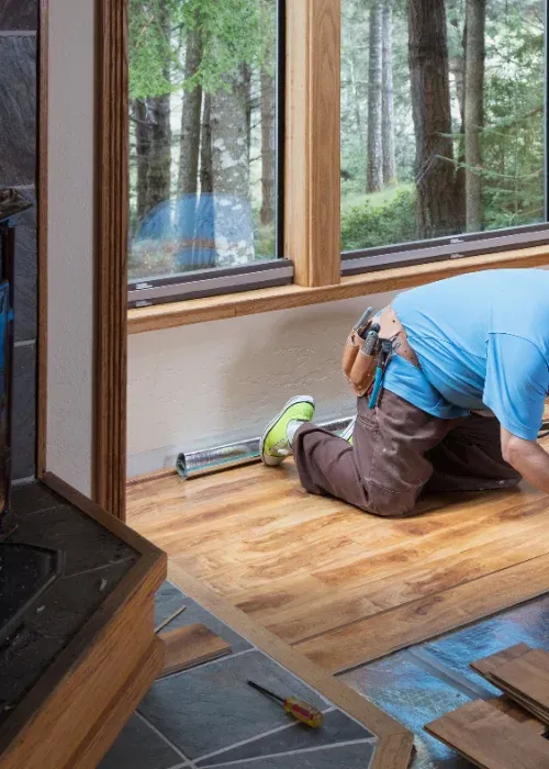 A Sartes installer working a plank into place
