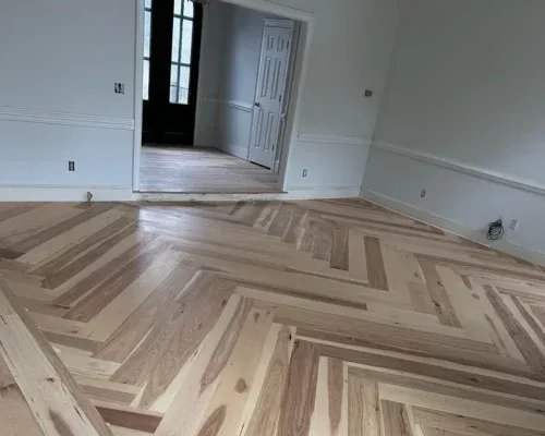 Herringbone hardwood floor laid across an open living room