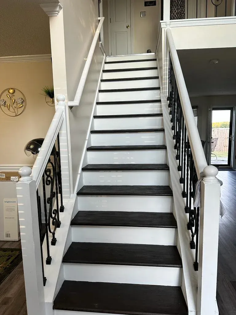 Black and white staircase with hardwood treads and painted risers